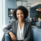 A friendly, diverse woman smiling in a clean, modern airport lounge setting.